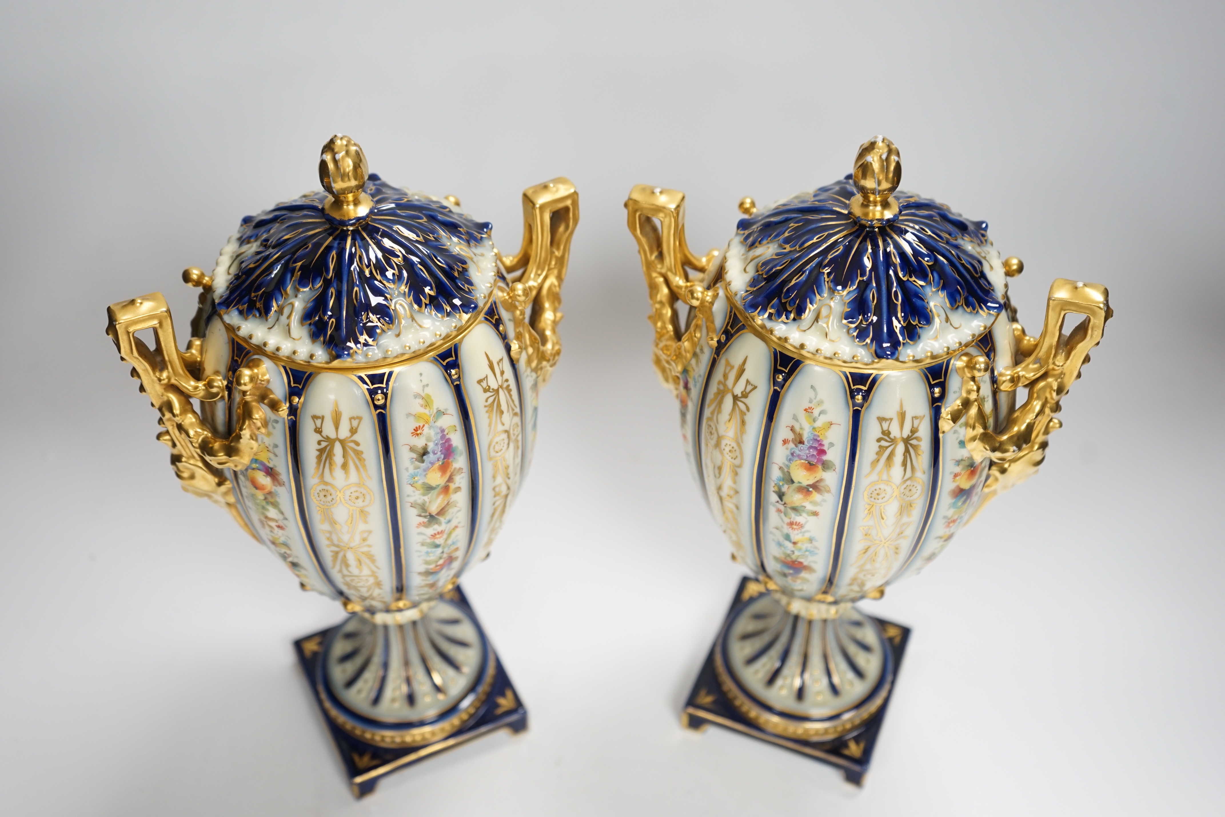 A pair of Rudolstadt gilt decorated urns and covers, 29cm